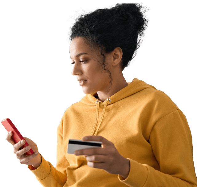 Medium skinned woman in orange sweatshirt entering information on phone
