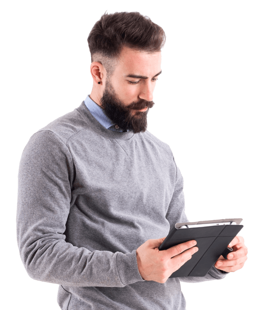 Light skinned man with a beard wearing gray sweater reading tablet
